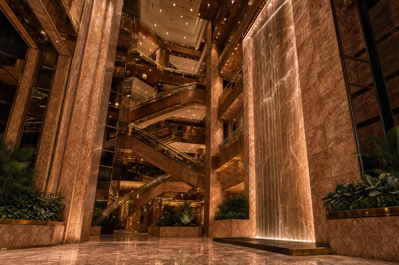 The Trump Tower atrium: peach marble, brass escalators and the indoor waterfall lit gold